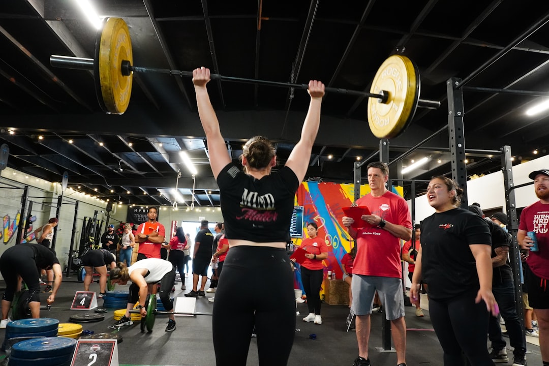 A weightlifter presses a heavy barbell overhead