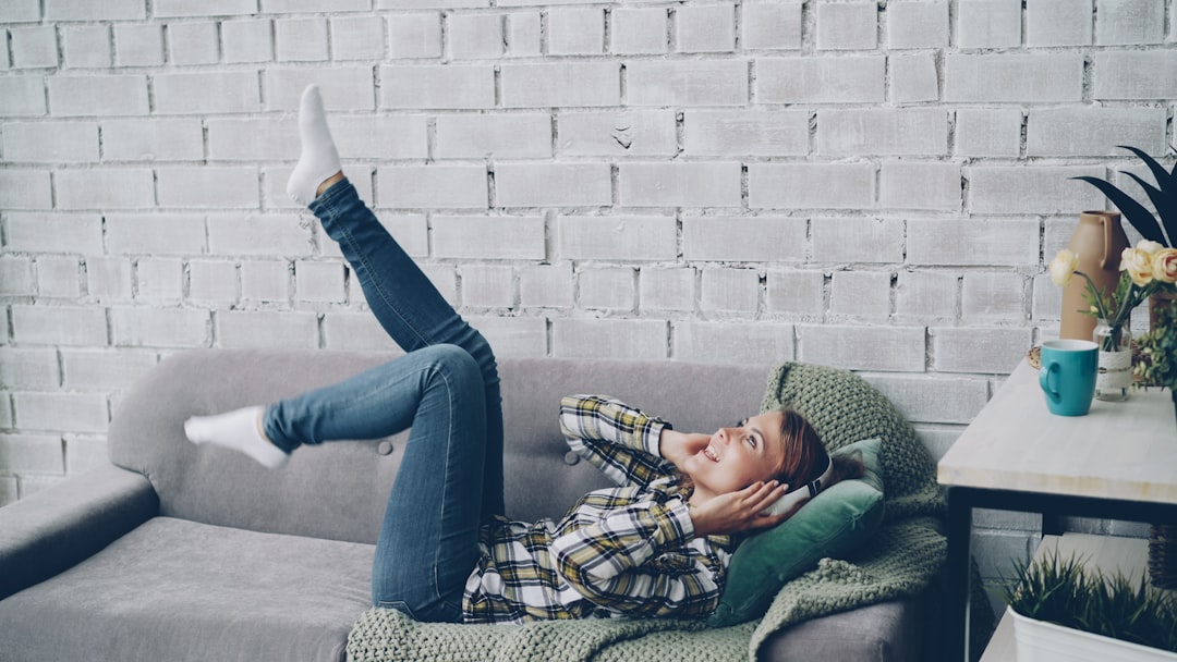 A woman lying on a sofa with legs in air