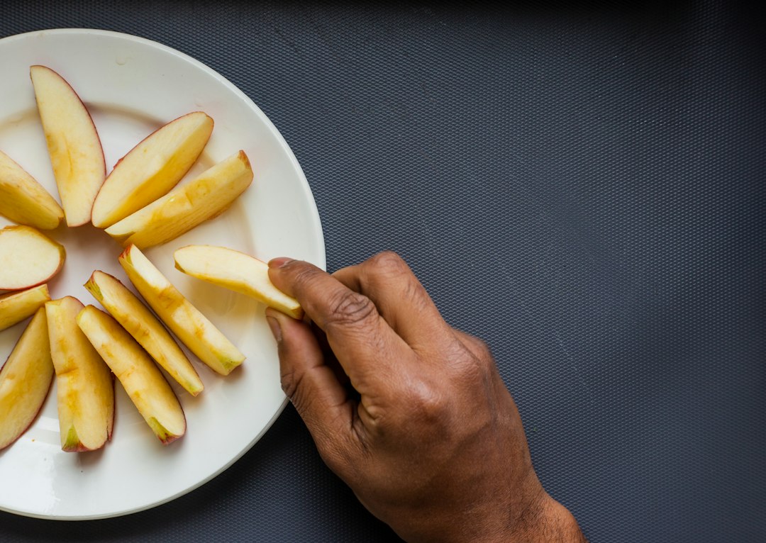 person holding white ceramic plate with yellow food