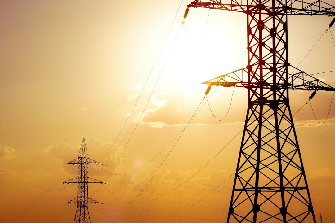 Power lines against a bright, yellow sky