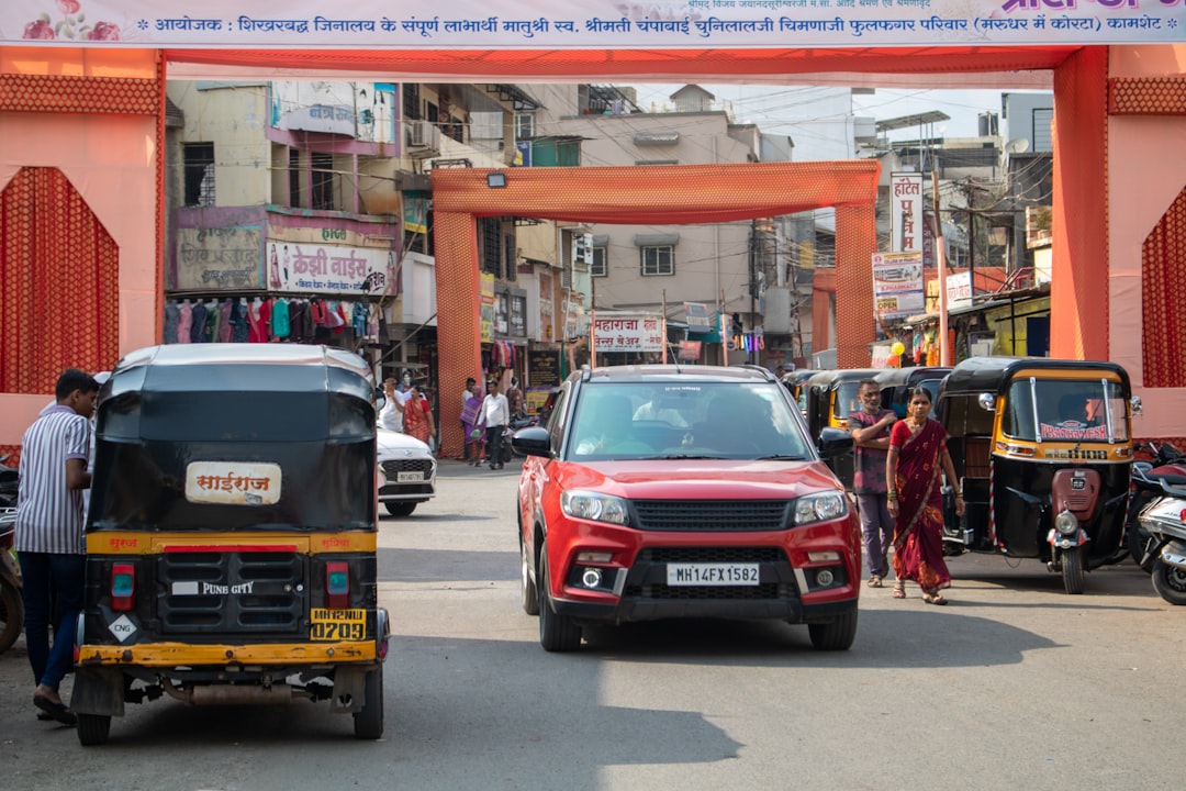 A group of cars driving down a street under a red sign