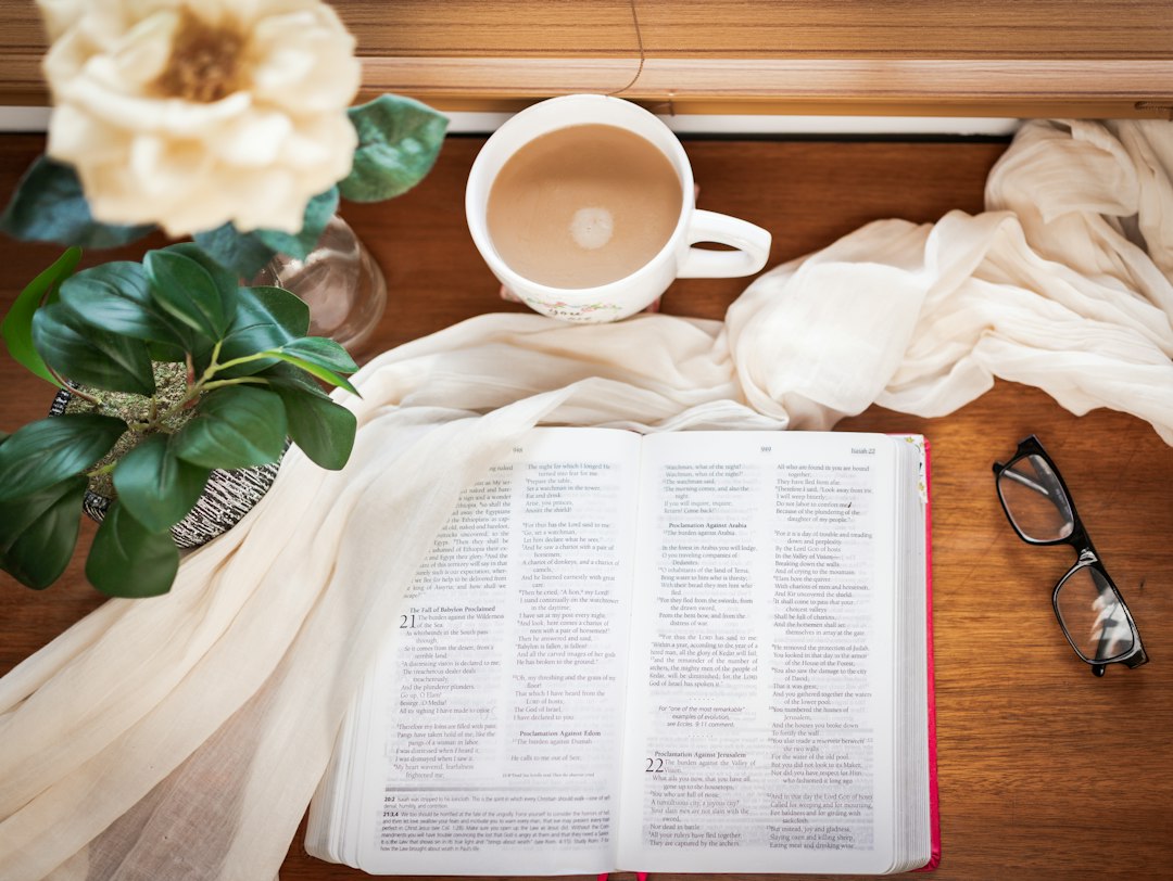 Open book with coffee and glasses on table