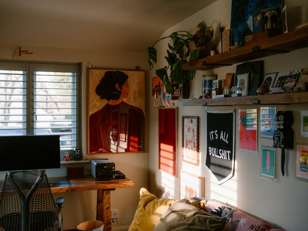 Sunlit room with art, plants, and a desk