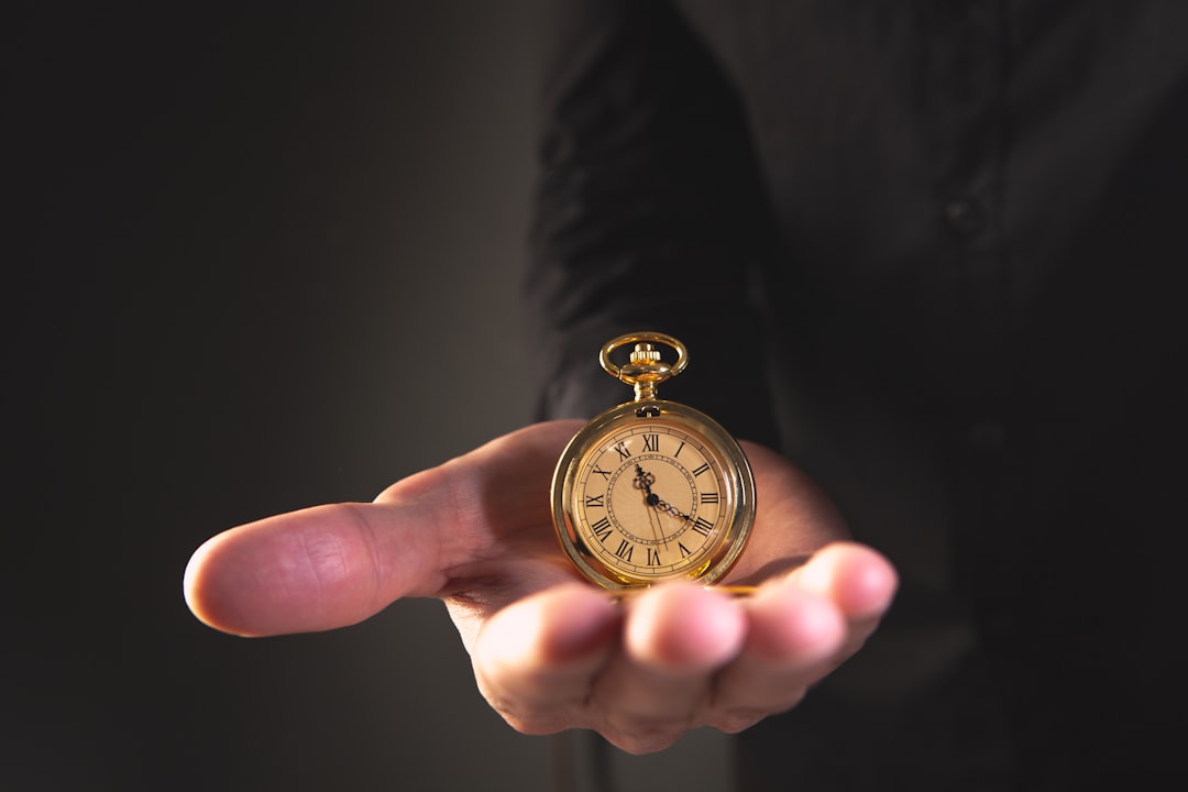 A person holding a vintage pocket watch in their palm