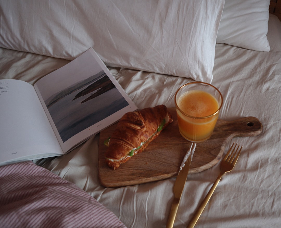 silver fork beside white ceramic mug on white textile