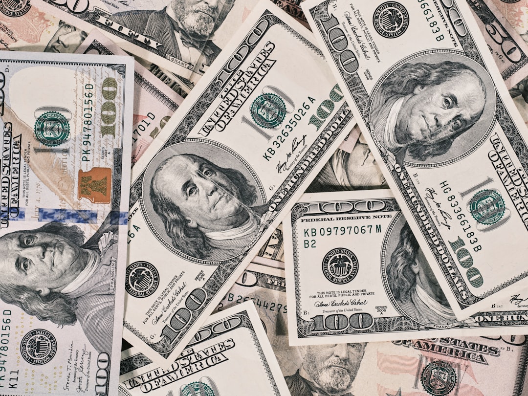 A scattered pile of American one hundred dollar banknotes